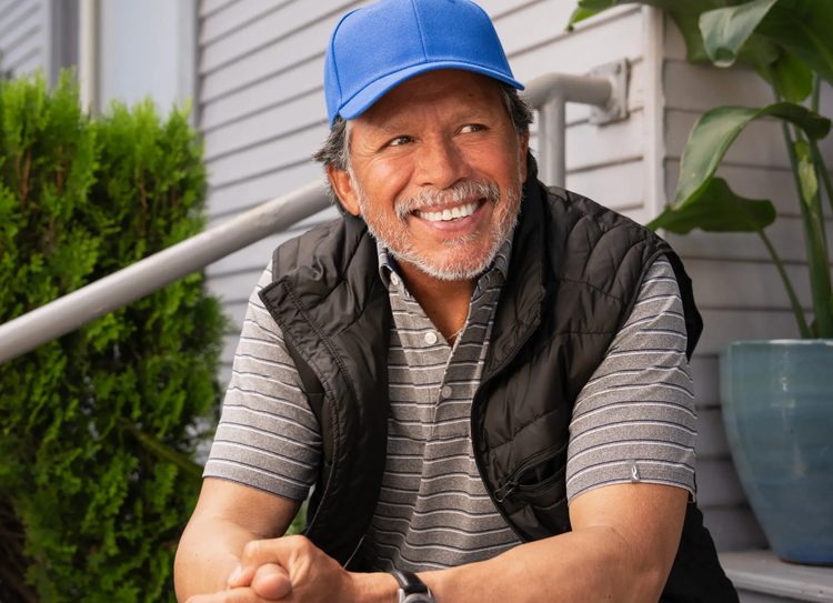 Smiling man sitting on his front steps